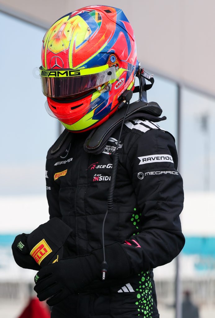 R-ace GP driver in a MegaRide-branded race suit